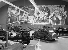 Lidingövägen 75, Kungliga Tennishallen. Volvoutställning, där bl. a. Volvo PV 444 presenteras. Stor reklamskylt i bakgrunden, med texten ""Svenska händer och hjärnor skapa Volvos värde""