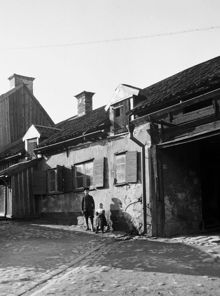 En flicka och en pojke står på gården vid Fatbursgatan 1 i kv. Lehusen. Nuvarande Fatbursgatan 29 A, kv. Färdknäppen
