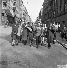 Fredsdagen den 7:e maj 1945.
Glada och flaggviftande människor firar freden längs Kommendörsgatan.