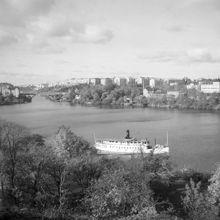 En ångbåt norr om Långholmen med Lilla Essingebron och Marieberg i fonden. Lilla Essingebron (1907-1962) är nuvarande Mariebergsbron