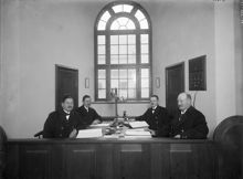 Porträtt av 4 uniformsklädda herrar sittande vid bord