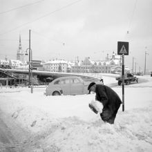 Södermalmstorg norrut. Renhållning vintertid. En man skottar snö