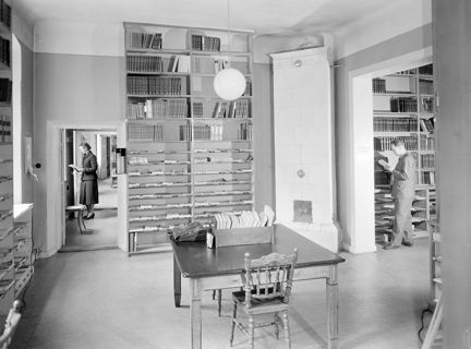 Biblioteksrum, två läsande personer.
