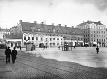 Hötorgets östra sida. Hötorget 14 och 12. T.h. mynnar Oxtorgsgatan. Tv. i fonden ligger Stora Bastugatan. Nuv. platsen för Konserthuset och 1:a höghuset vid Sergelgatan