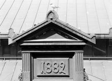 Hötorgshallen före rivningen 1954. Byggnadsdetaljer vid taket med årtalet 1882 då saluhallen byggdes. En skrattmås ser ut över torget