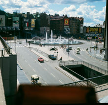 Vy från terrassen vid Göteborgs Banks hus på Sveavägen mot Sergelstorgsfontänen. I fonden kv. Skansen och Fyrmörsaren med fasadreklam för bland andra Luxor, Fiat, Pommac och Tend