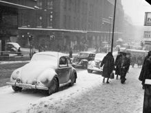 Hörnet Hamngatan-Regeringsgatan. Gatumiljö i snöväder. T. v. Hamngatan 18-20, NK (Nordiska Kompaniet)