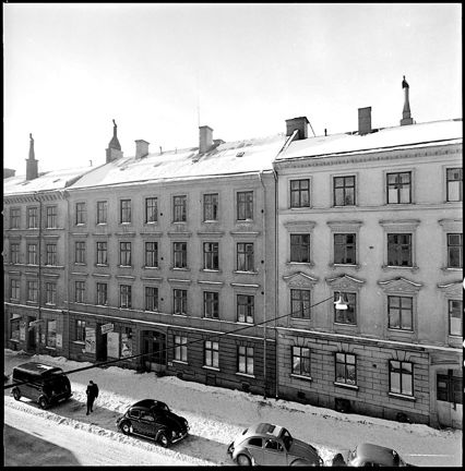 Husfasader, parkerade bilar, snö.