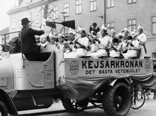 Musikframträdande på Barnens dag. En blåsorkester sitter på ett lastbilsflak, som gör reklam för Kejsarkronans vetemjöl