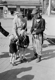 Tegelbacken. Jur. studerande Lars Nycander, utklädd till clown, säljer nyckelhäfte med ""nycklar"" till Stockholm. Nyckelhäftet innehåller rabattkuponger till evenemang vid Stockholms 700-års jubileum