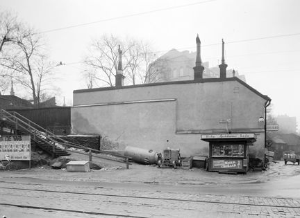 En kiosk står intill brandmuren mot Renstiernas Gata tillhörande Tjärhovsgatan 35. Mamsell Josabeths Trappor t.v. Nuvarande Tjärhovsplan, kv. Roten